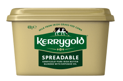 Pack shot of a Kerrygold Spreadable tub on a plain background, featuring a gold container with green Kerrygold logo and text highlighting blended Irish butter with rapeseed oil made from milk from Irish grass-fed cows.