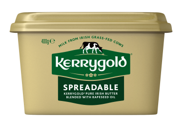 Pack shot of a Kerrygold Spreadable tub on a plain background, featuring a gold container with green Kerrygold logo and text highlighting blended Irish butter with rapeseed oil made from milk from Irish grass-fed cows.
